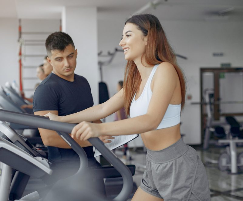 Young sports people training in a morning gym Handsome man in a gym. Sportspeople in a sportswear. Woman training with coach